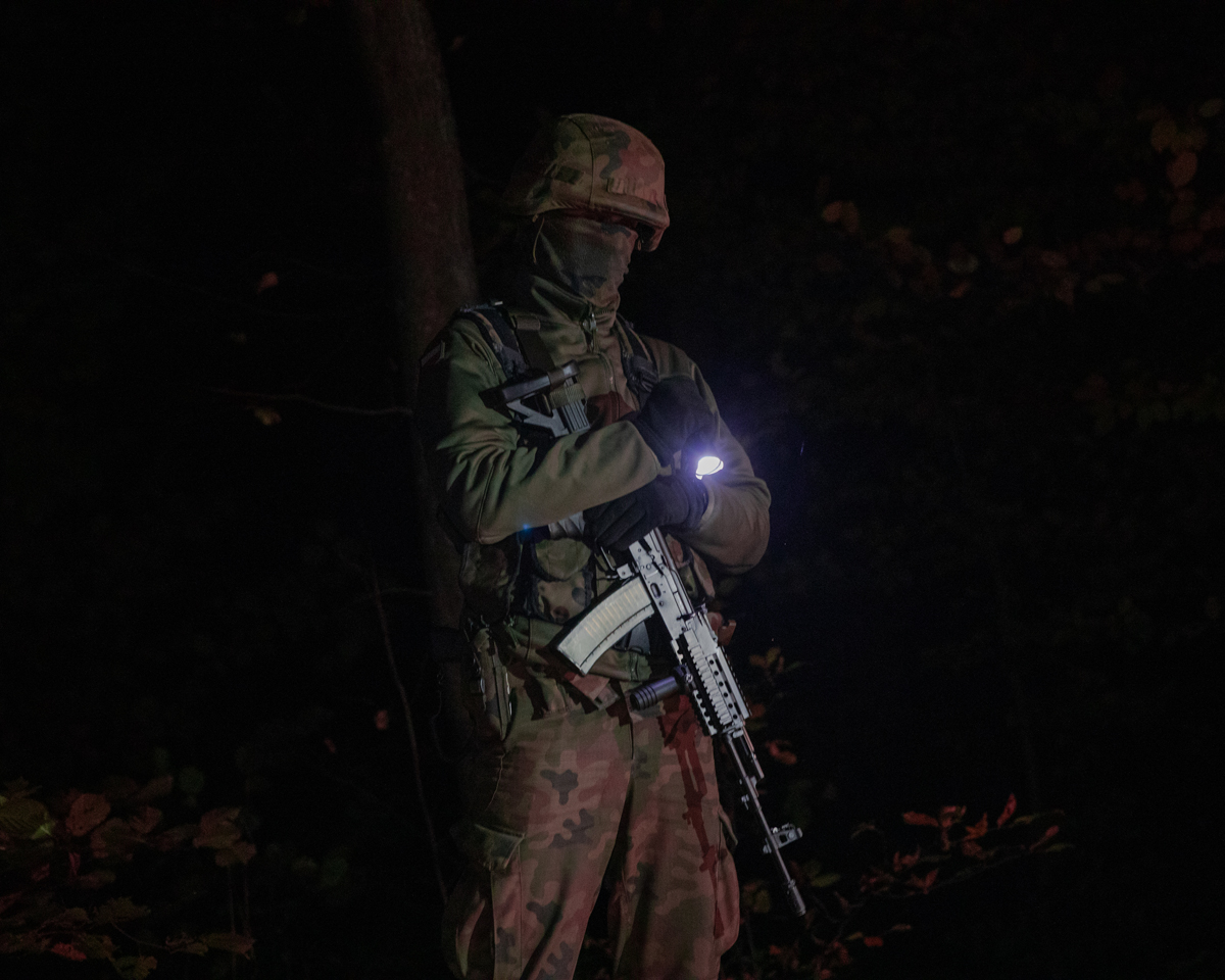 10.10.2021. Подляское воеводство, Польша. Польские солдаты присматривают за семьей беженцев, которую берут под стражу в лесу / © Енджей Новицки