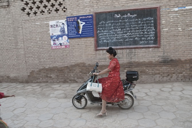 Chinesin auf einem Motorroller in Kaxgar, 2007 / Foto © Konstantin Salomatin