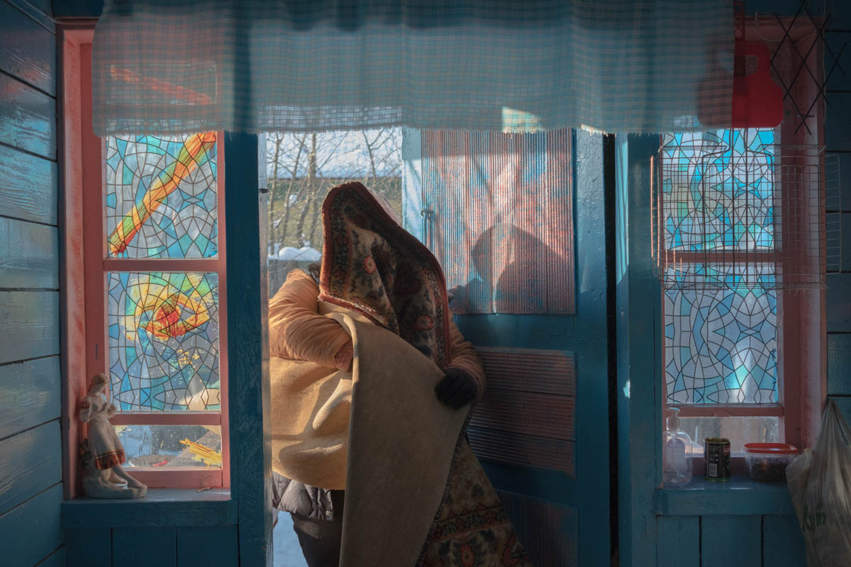 Mama bringt nach der Reinigung im Schnee den Teppich herein, Malostowka, Januar 2021 / Foto © Tatsiana Tkachova