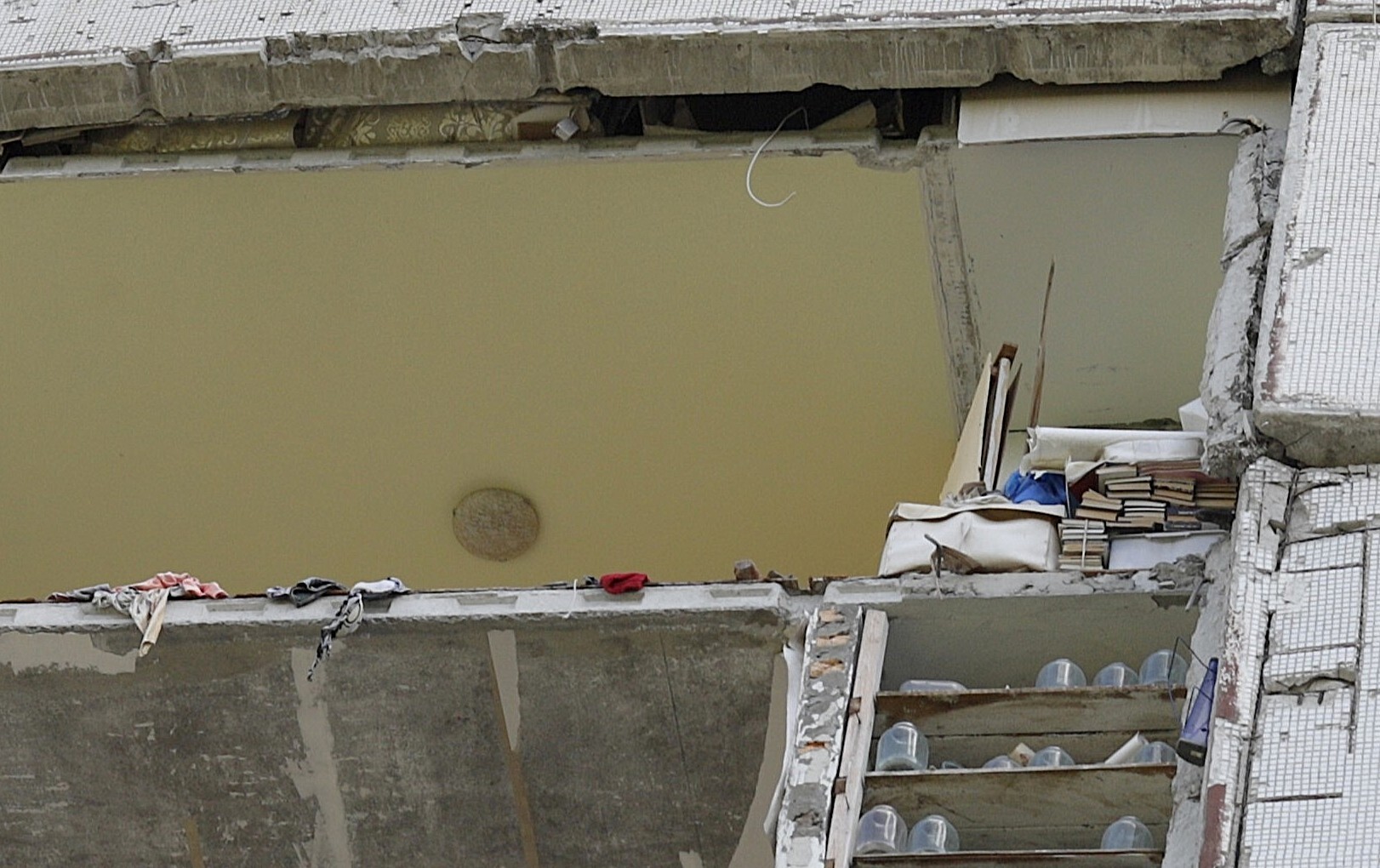 Ein Bücherstapel hat einen russischen Raketenangriff im Charkiwer Plattenbaugebiet Nord-Saltiwka überstanden. / Foto © Peggy Lohse/dekoder, 08/2025