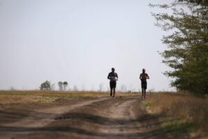 Symboldbild zweier rennender ukrainischer Soldaten als Illustration für eine Kolumne über vier Jahre Kriegsdienst und Debatten um die Mobilisierung in der Ukraine.