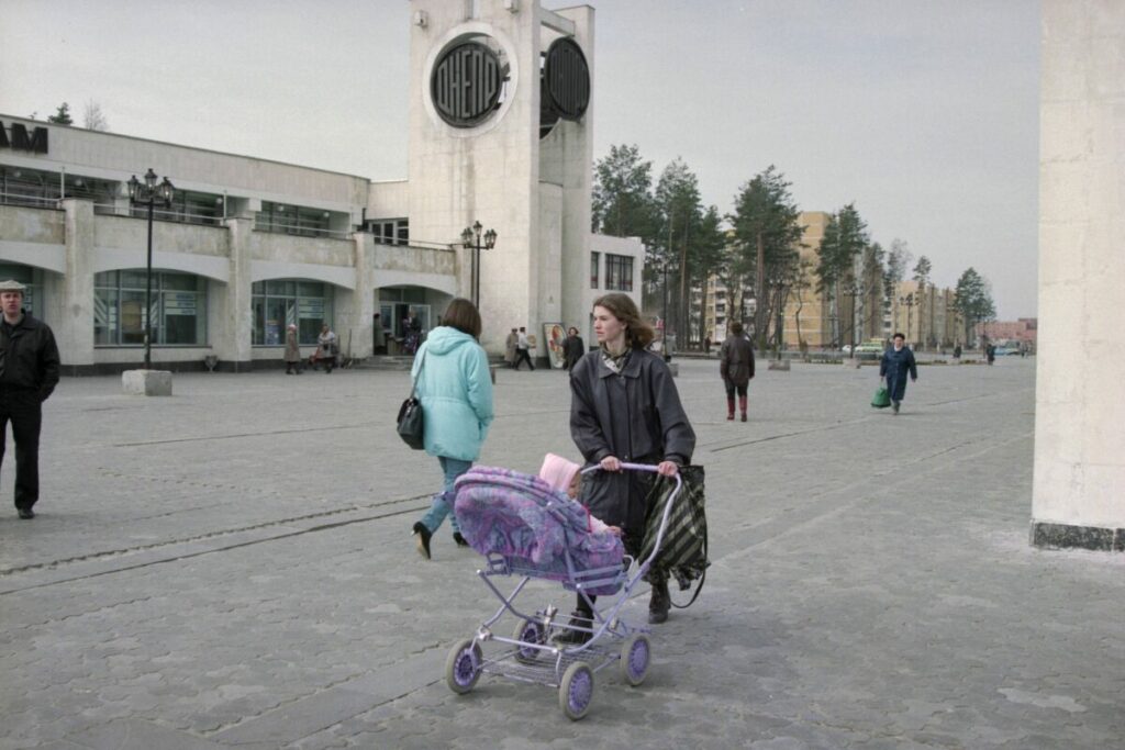 Slawutytsch im April 1996: Zwischen anderen Menschen spaziert eine junge Mutter mit Kinderwagen auf dem zentralen Platz vor dem Einkaufszentrum „Dnipro“ / Foto © Anatoly Morkovkin/Itar-Tass/Imago 