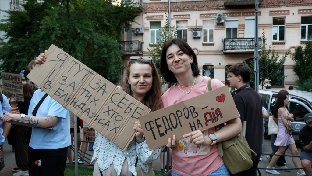 Tetjana Kopajhorodska (links) und Marija Melnyk (rechts) beim Papp-Protest Ende Juli 2026 in Kyjiw: „Ich bin hier für mich und für die in den Schützengräben“ und „Federow in Aktion“ / Foto © Olexandra Jefymenko/Zmina